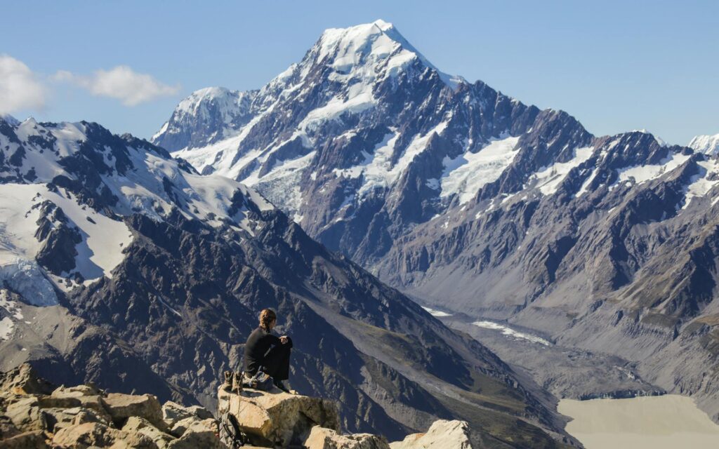 Snow capped mountain with hiker on a mountain top