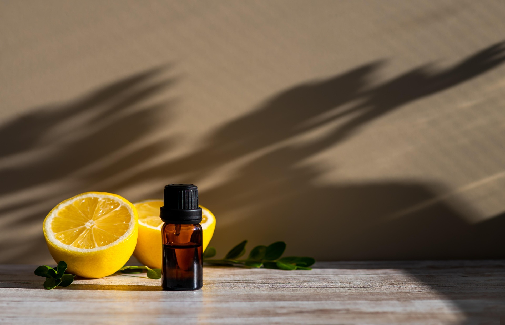 Essential Oil bottle and lemons on a wellness background