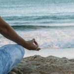 Woman meditating on the beach