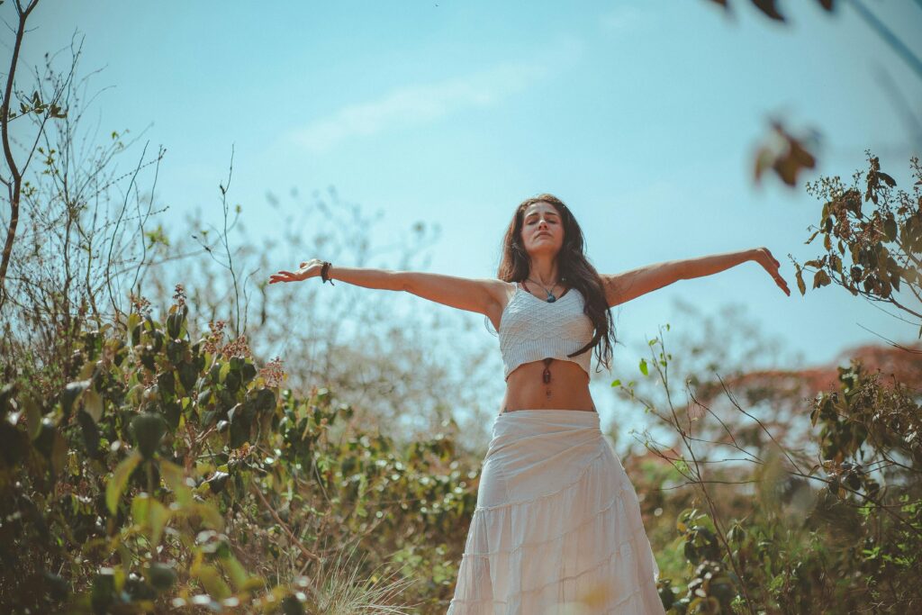 Woman with arms up, breathing in nature