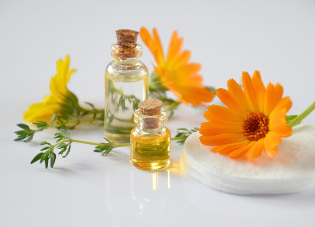 Body massage oil, two oil bottles and natural yelow flowers around
