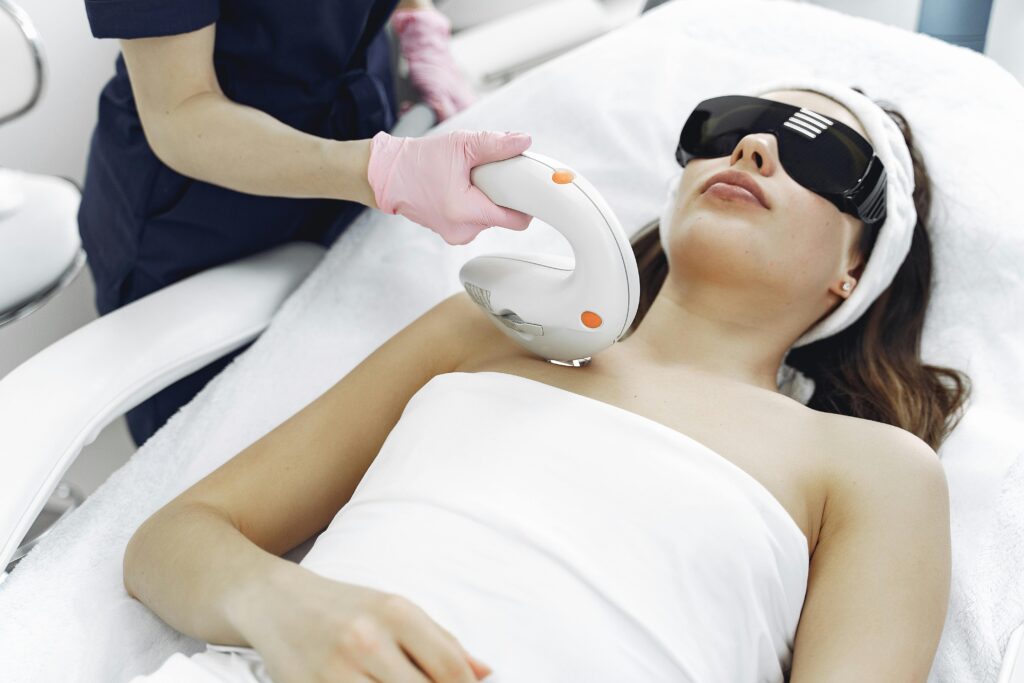 Pacient lady receiving a laser treatment by a doctor on a profesional beauty treatment bad