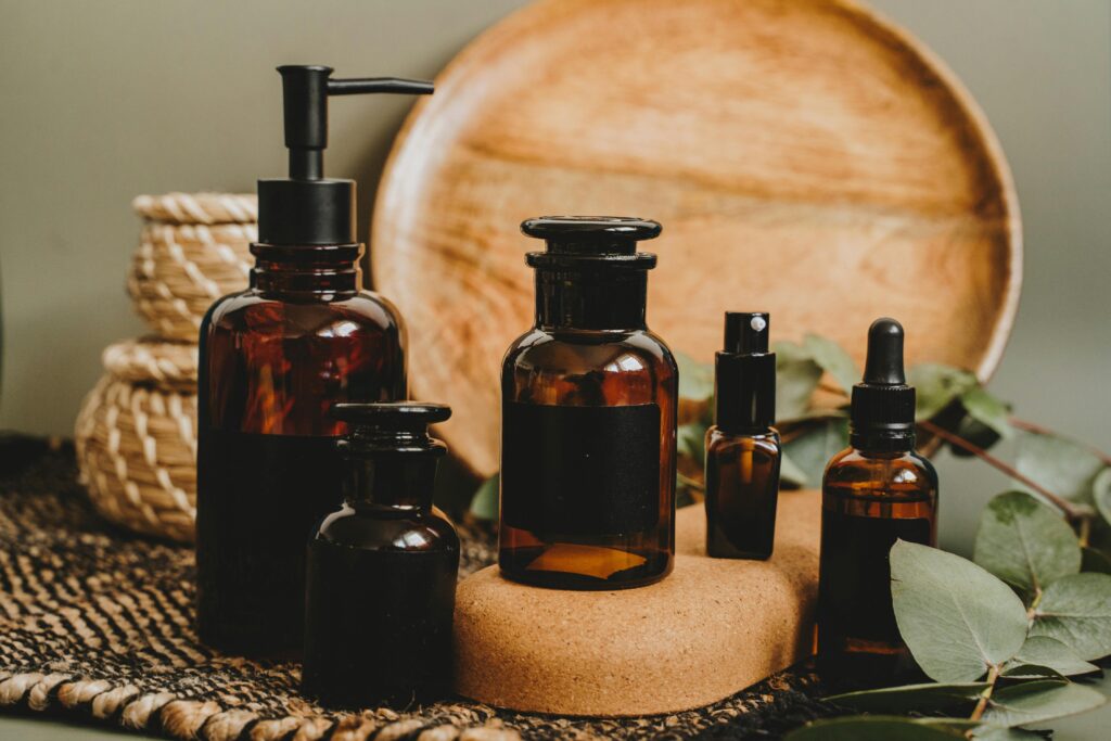Essential oil botles small and big, wood and green leaf