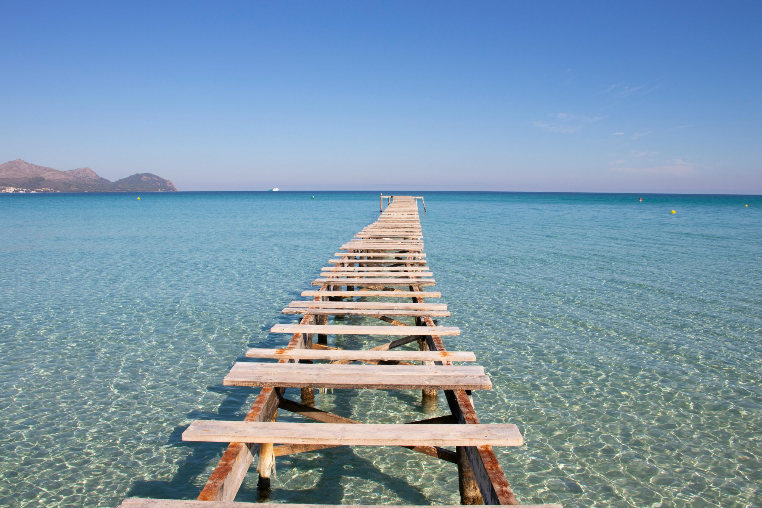 Walking bridge on top of clear sea water