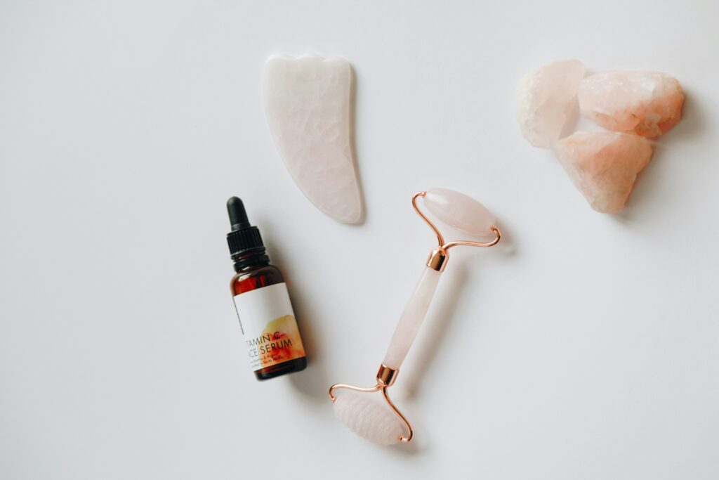 Pink gua sha, jade roller and vitamin C for face skin care ritual