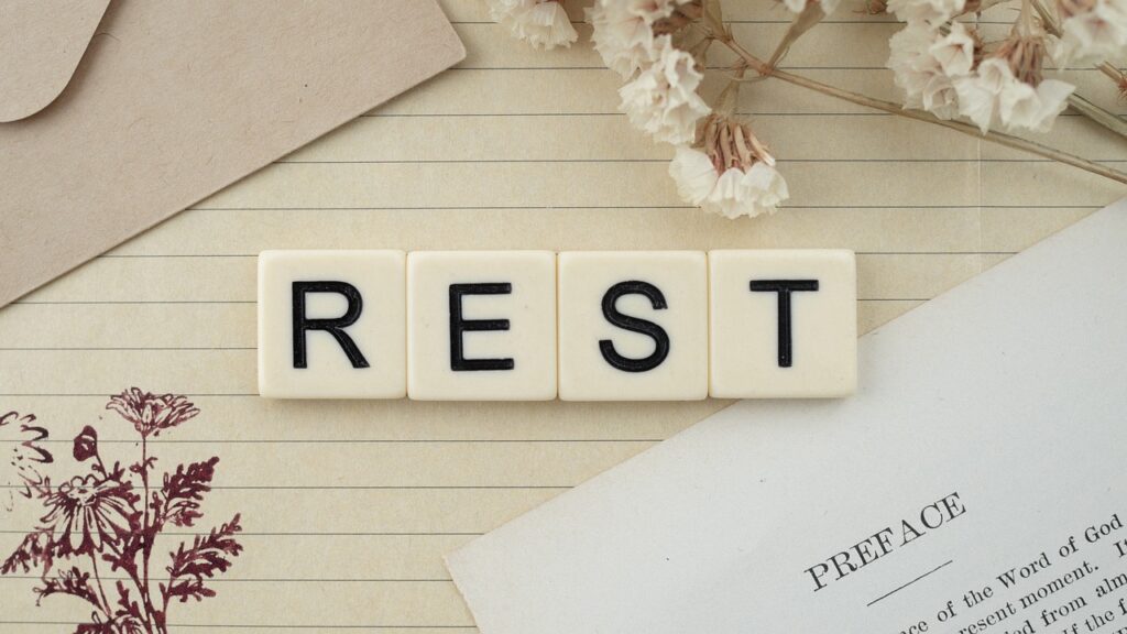 Word REST, flowers and a written paper encouraging self-care practices