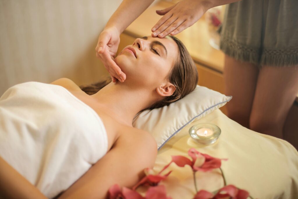 Lady having a lymph drainage massage from a profesional therapistand pink flowers on the bed