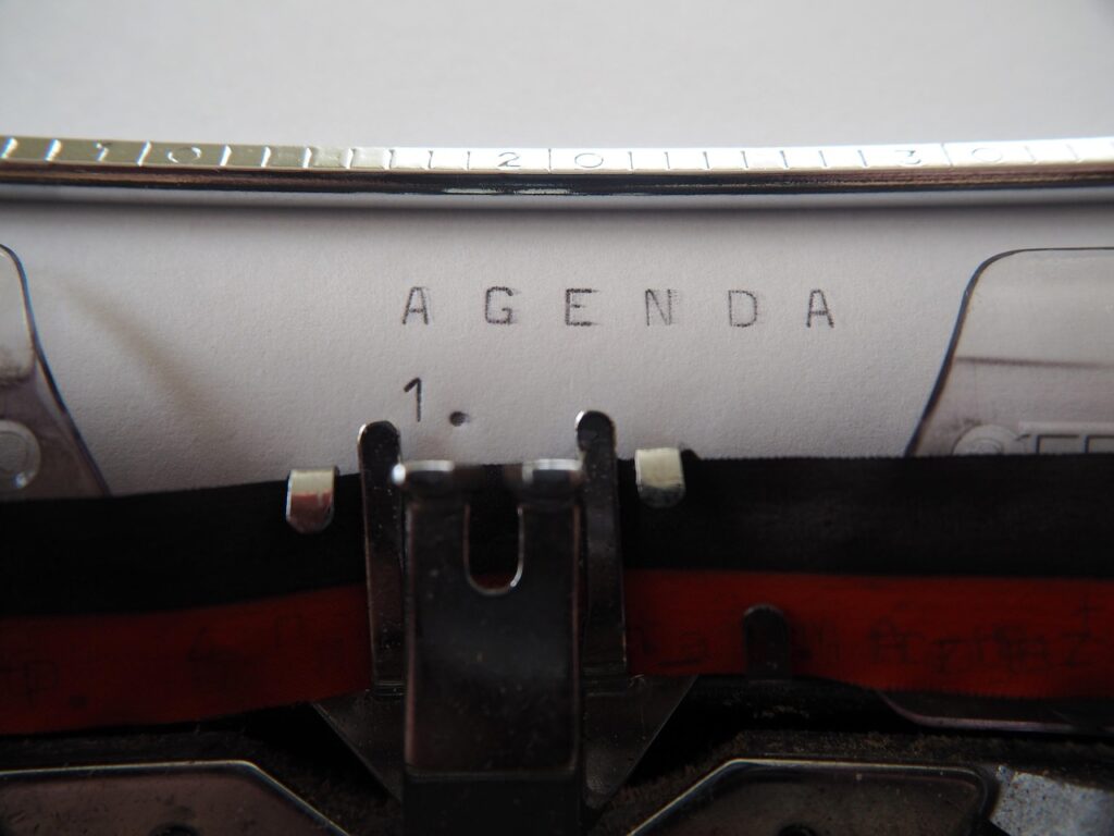 Letters on a sheet of paper with the message AGENDA, written by a pencil