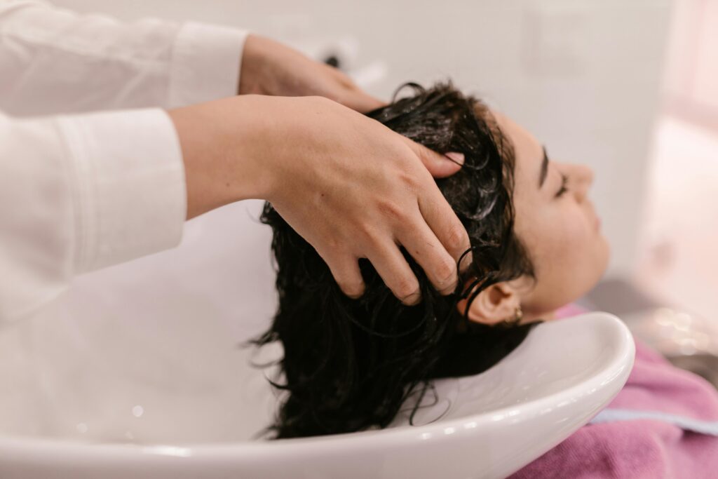 Woman receiving a hair treatment by hair profesional