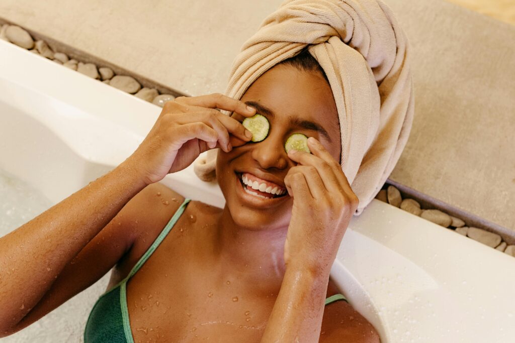 Spa at home ritual, woman inside a bath with 2 pieces of cucumber placed on the eyes