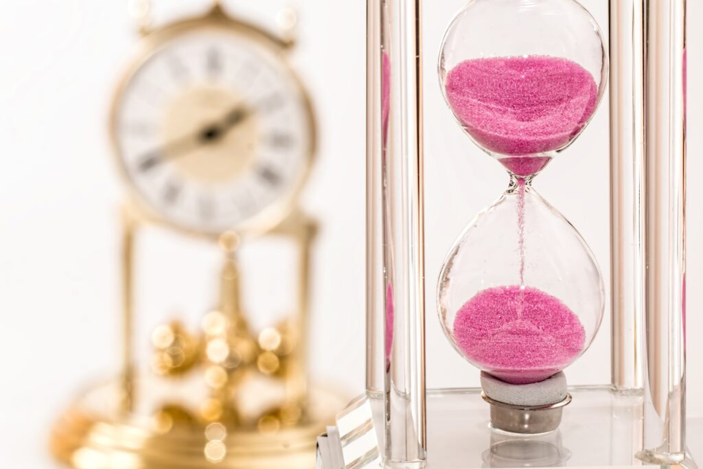 Howerglass pinck color and vintage gold clock near 