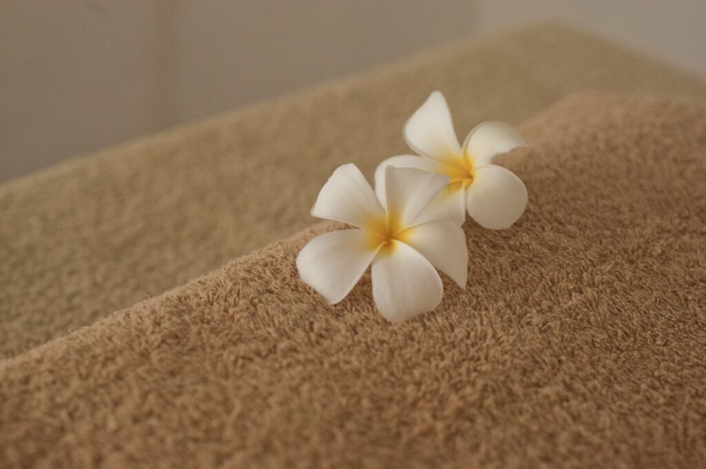 Premium massage experience brown towels and white flowers