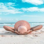 summer hydration rituals, woman wearing a sun heat on the beach