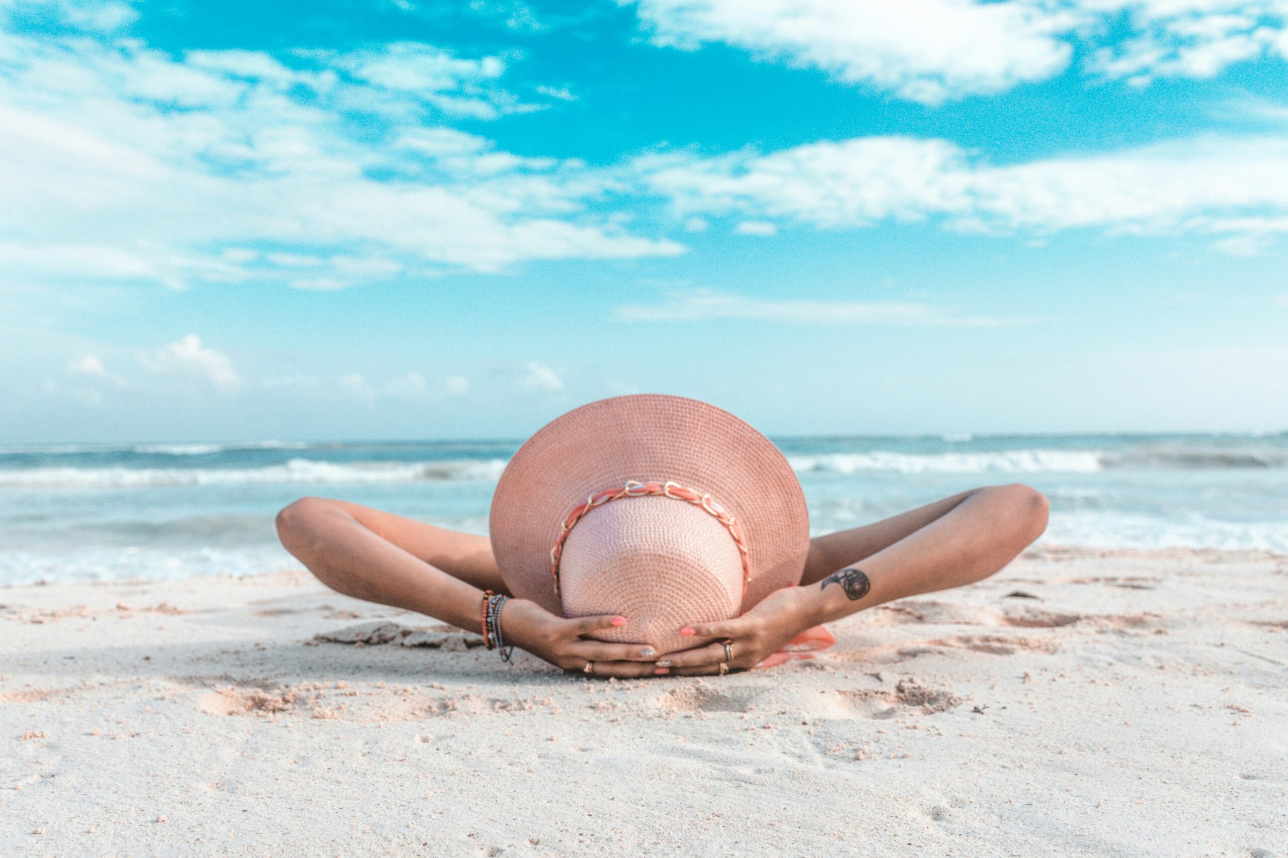 summer hydration rituals, woman wearing a sun heat on the beach