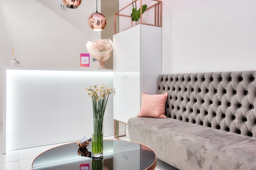 Massage salon reception with sofa , table with a flower and desk for massage bookings