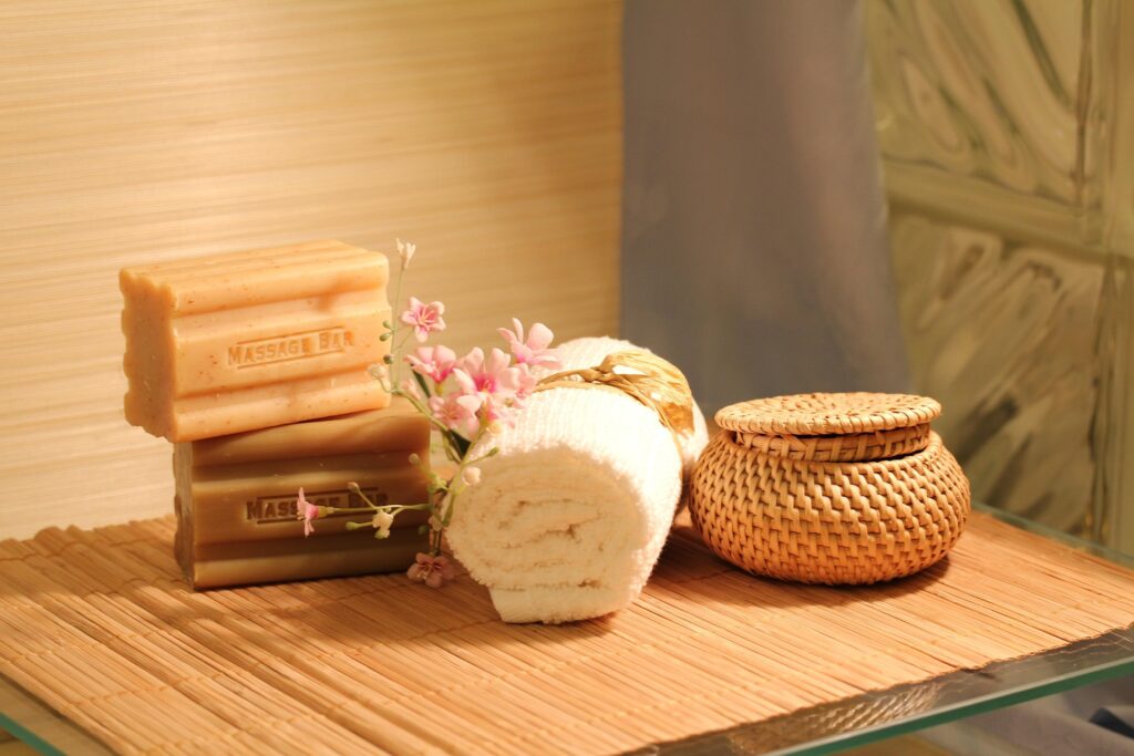 Massage therapy spa setup with soap bars, rolled towel and flowers.