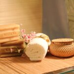 Massage therapy spa setup with soap bars, rolled towel and flowers.